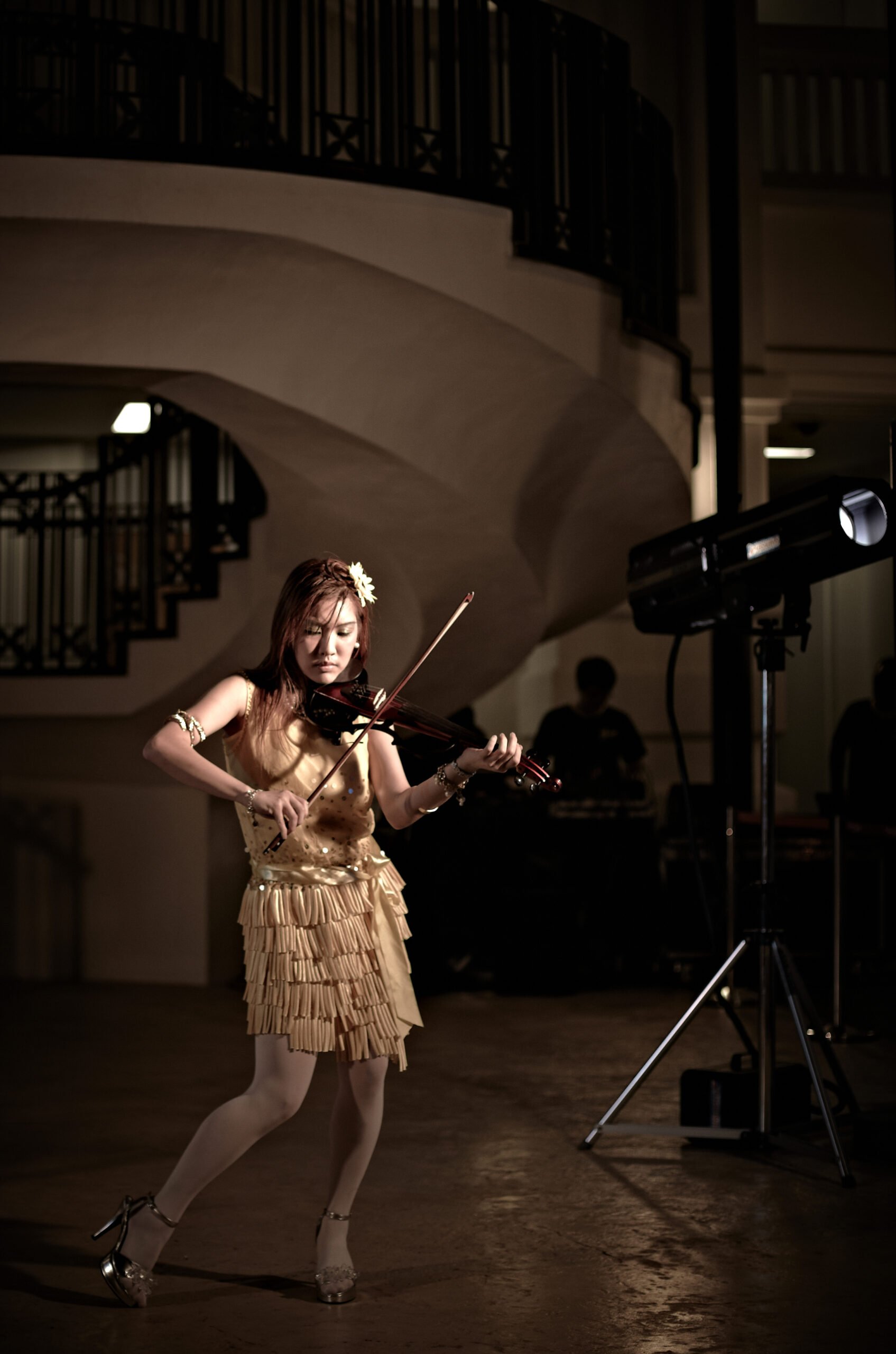 Adult musician playing violin in a dynamic pose, highlighting expressive performance skills taught in advanced music lessons