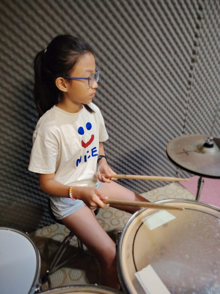 Child student playing drum kit