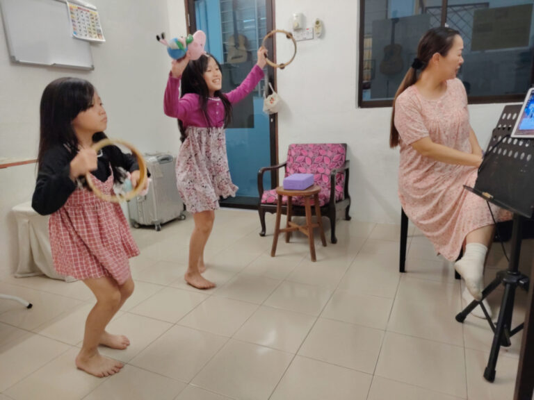 Child students dancing and singing holding percussion instruments
