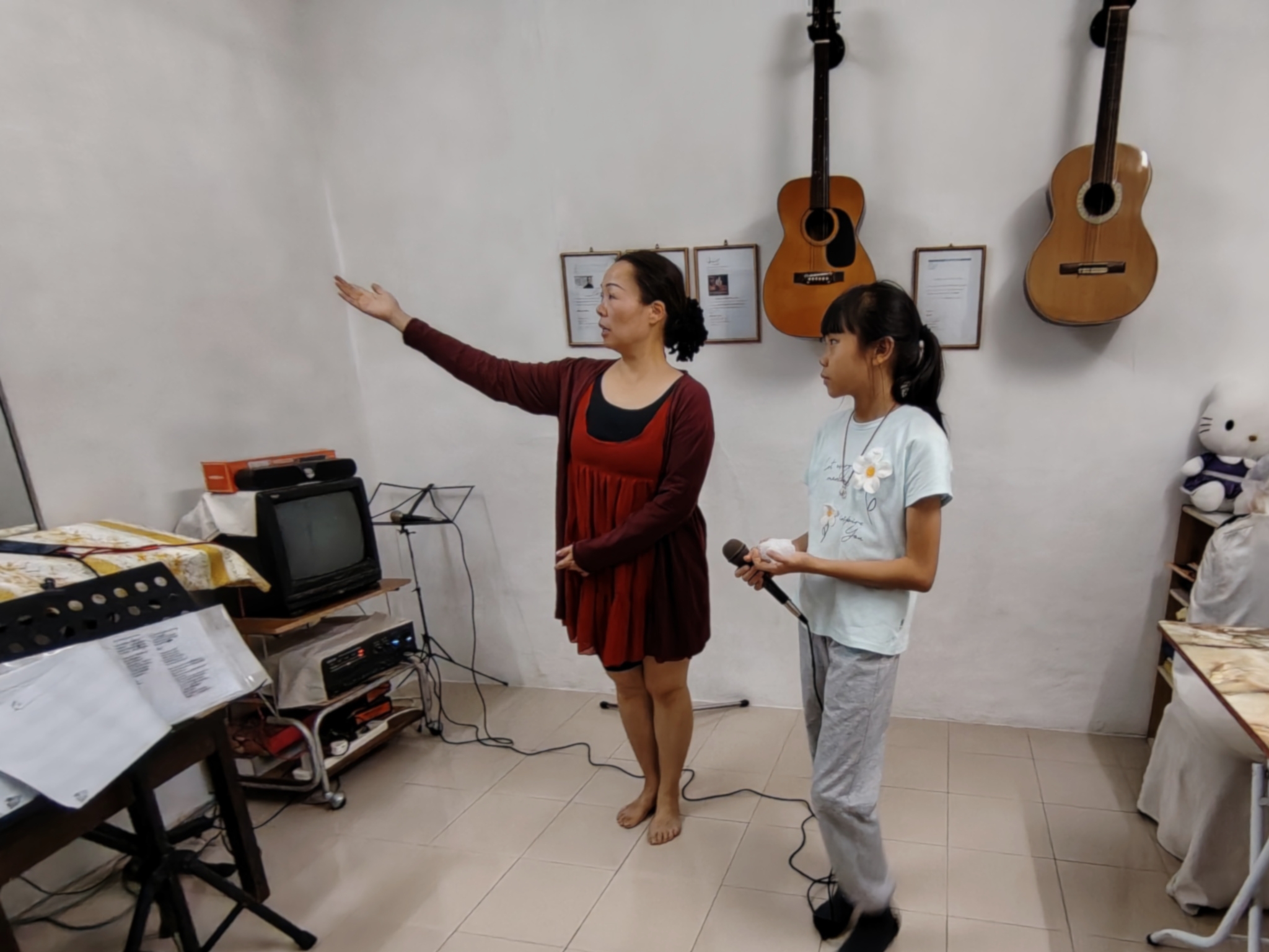 A teacher demonstrating vocal performance techniques in a singing class