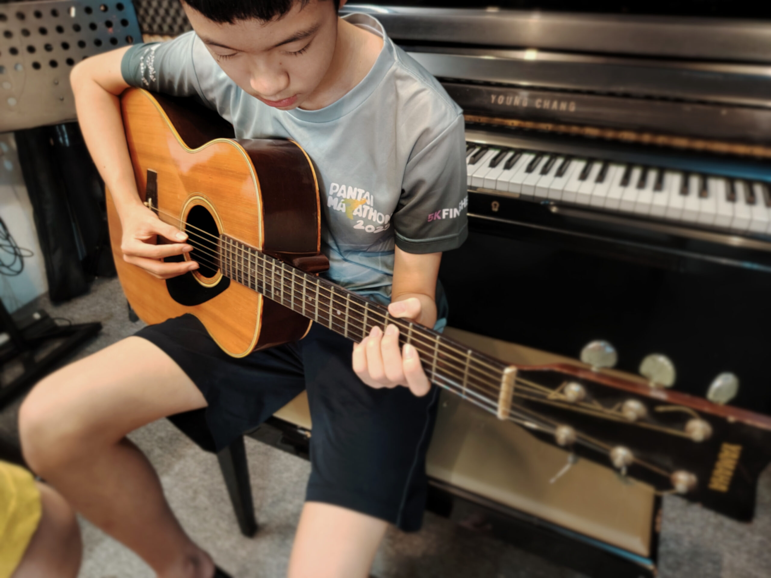 Young student playing guitar during class
